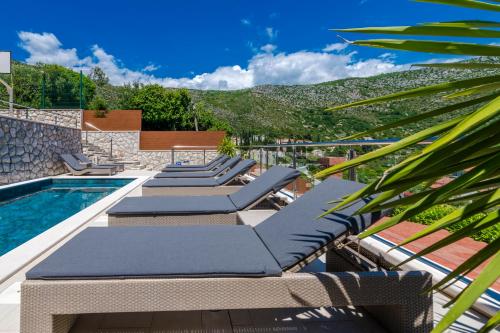 a pool with chaise lounge chairs and a swimming pool at Vacation home with Private heated Pool in Zaton
