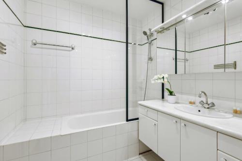 une salle de bain blanche avec une baignoire et un lavabo dans l'établissement Amazing Apt 3BDR near The Eiffel Tower, à Paris