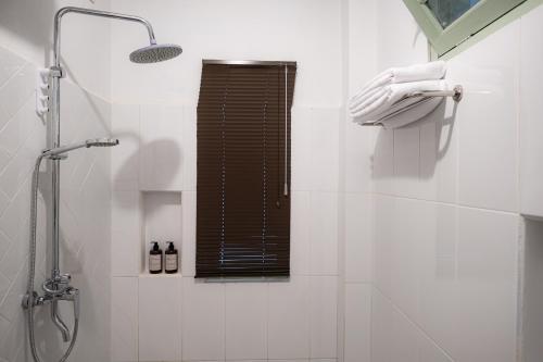a white bathroom with a shower and a window at Entire Heritage Villa Family friendly in the Center of Yogya with Swimming Pool - Up to 9 people in Yogyakarta