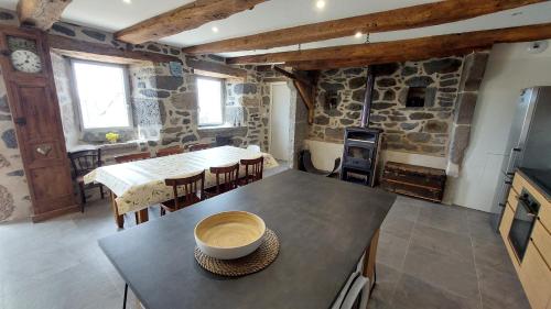 - une cuisine et une salle à manger avec une table et une cuisinière dans l'établissement Gite sur les hauteurs de Cassuéjouls, à Cassuéjouls