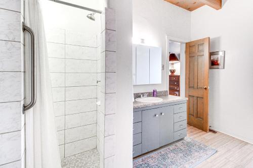 a white bathroom with a sink and a shower at 3 Mi to Zoo and Garden ABQ Home with Heated Pool! in Albuquerque