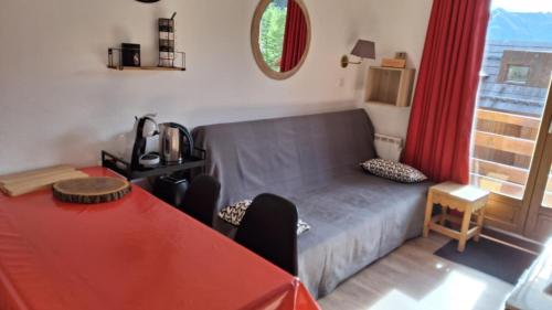 un salon avec un canapé et une table dans l'établissement CŒUR D'ALTAÏR RISOUL 1850 Appartement T2 confortable skis aux pieds, à Risoul