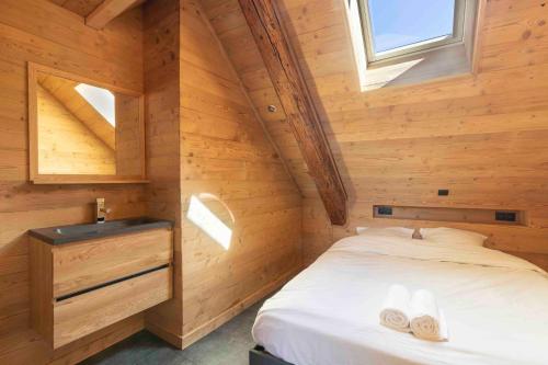 ein Schlafzimmer in einem Blockhaus mit einem Bett und einem Waschbecken in der Unterkunft Cabana & La Grange aux 7 Marmottes in Saint-Alban-des-Villards