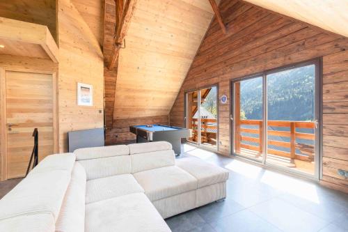 ein Wohnzimmer mit einem weißen Sofa und einem Billardtisch in der Unterkunft Cabana & La Grange aux 7 Marmottes in Saint-Alban-des-Villards
