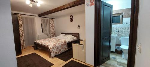 a small bedroom with a bed and a bathroom at Pensiunea Montan in Durău