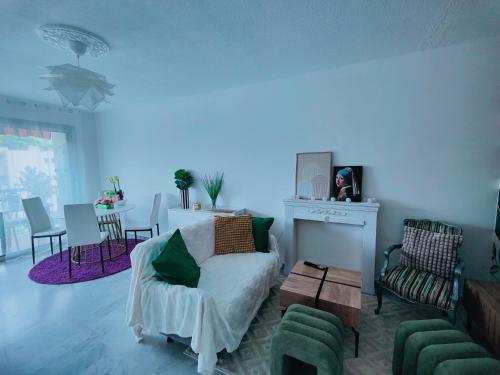 un salon avec un lit, une table et des chaises dans l'établissement Beau T3 au calme près gare, mer et centre ville, à Antibes