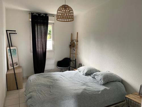 - une chambre avec un lit et une lampe pendant dans l'établissement Appartement 2 pièces à La Teste avec piscine, à La Teste-de-Buch