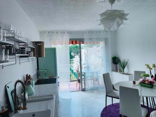 une cuisine avec une table et des chaises ainsi qu'une salle à manger dans l'établissement Beau T3 au calme près gare, mer et centre ville, à Antibes