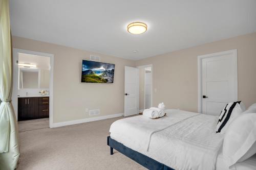 a white bedroom with a bed and a bathroom at Luxury Niagara 3 Bdr Townhouse /Garage in Niagara Falls