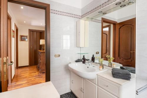 een witte badkamer met een wastafel en een spiegel bij Anna luxury apartment Salario Parioli Rome in Rome