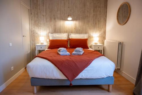 une chambre avec un grand lit avec deux serviettes dessus dans l'établissement Gîte des Mottes, à Saint-Jean-de-Beugné