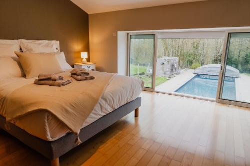 - une chambre avec un lit et une vue sur la piscine dans l'établissement Gîte des Mottes, à Saint-Jean-de-Beugné