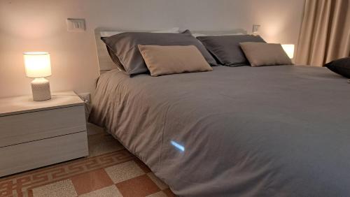 a bedroom with a large bed with a lamp on a dresser at Sea Vibes - Rome in Lido di Ostia