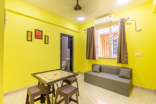 a living room with yellow walls and a couch and a table at 3BHK Villa - The Blue Pearl Varca Beach in Varca