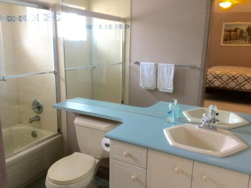 a bathroom with a sink and a toilet and a shower at Vancouver Pacific Guest House in Richmond