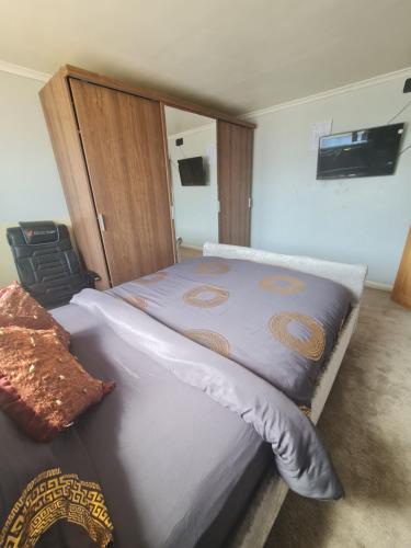 a bedroom with two beds and a tv on the wall at The Rushdon in Grays Thurrock