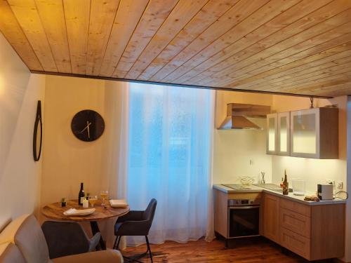 eine Küche mit einem Tisch und einer Uhr an der Wand in der Unterkunft appartement cosy in Villefranche-sur-Saône