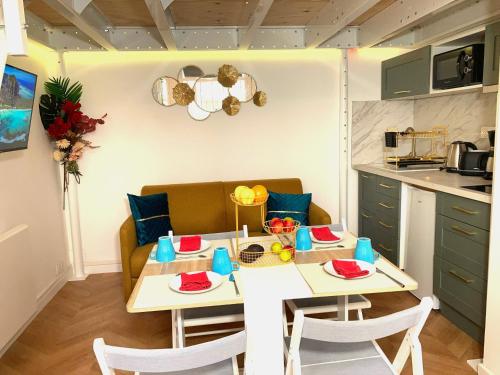 Un comedor con una mesa y una cocina. en Studio de Rêve à Versailles Plein Centre , 500m Château, 350m Gare Rive Gauche, en Versalles