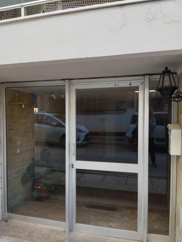 a sliding glass door to a garage with cars in it at Dim-Paul in Artemida