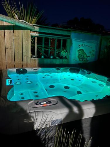 une baignoire jacuzzi devant une maison la nuit dans l'établissement Détente et Spa au cœur des vignes !, à Moulis-en-Médoc