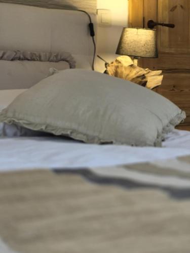 a pillow sitting on top of a bed with a lamp at La Ferme de la Cour in Herbeumont