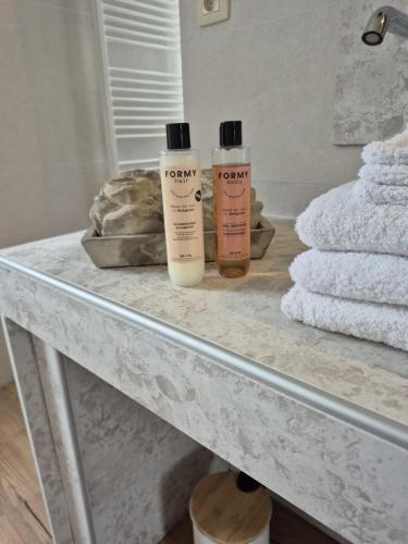 two bottles ofodorizers sitting on a table with towels at La Ferme de la Cour in Herbeumont