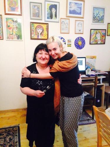 two women hugging each other in a room at Nitsa Guest House in Gori