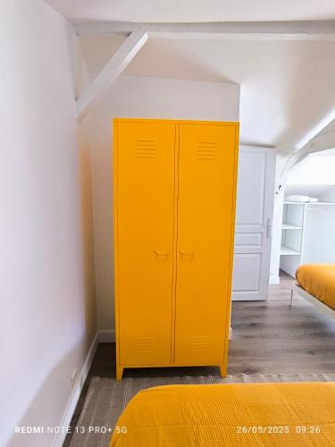 a yellow cabinet in a room with a bed at Le Gîte des Capucines in Mauléon