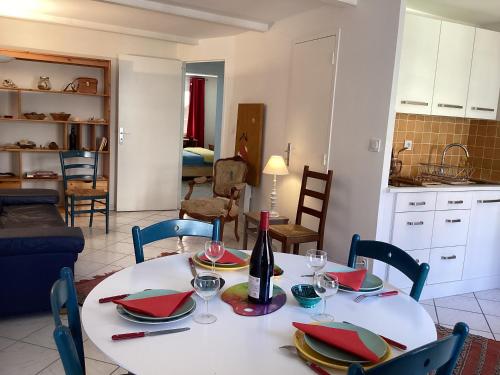 une table de salle à manger avec une bouteille de vin dessus dans l'établissement Appartment place d'équerre, à Toulon
