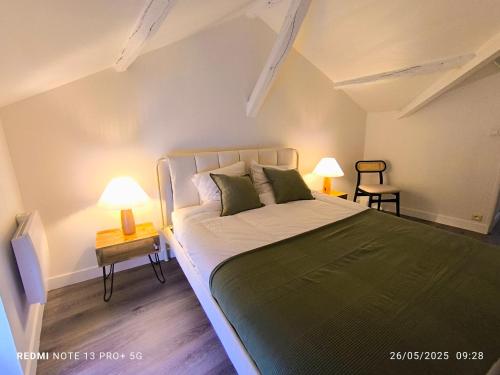 a bedroom with a large bed and two lamps at Le Gîte des Capucines in Mauléon