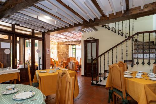 Un restaurante con mesas y sillas amarillas y una escalera. en CASA PAZOS-ARBO, en Arbo