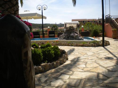 a swimming pool with a fountain in a resort at ILENIMA Hotels in Agios Stefanos