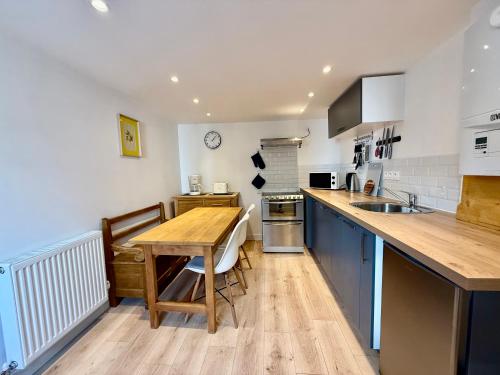 - une cuisine avec une table en bois et un comptoir dans l'établissement La Schlucht, bel appartement & centre-ville, à Gérardmer