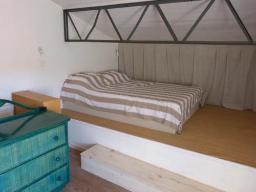 une chambre avec un lit et une commode en bois dans l'établissement Renée, à Banyuls-sur-Mer