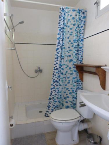une salle de bain avec toilettes et rideau de douche dans l'établissement Renée, à Banyuls-sur-Mer