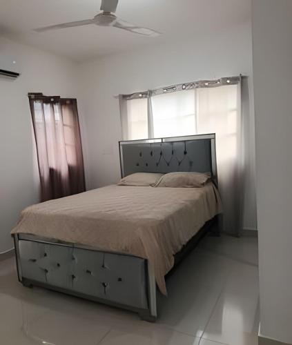 a bed in a white room with windows and a ceiling at Casa cerca del aeropuerto. in Monte Llano