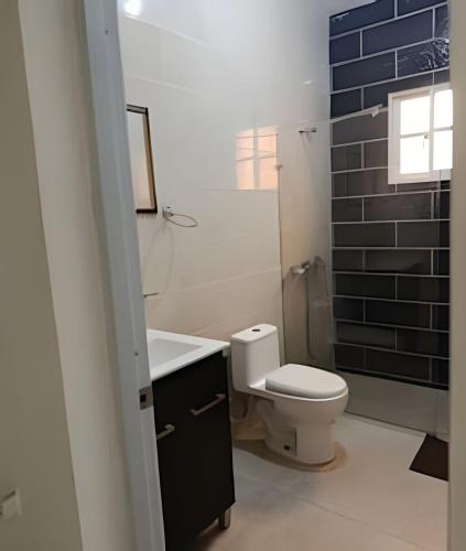 a bathroom with a toilet and a sink at Casa cerca del aeropuerto. in Monte Llano