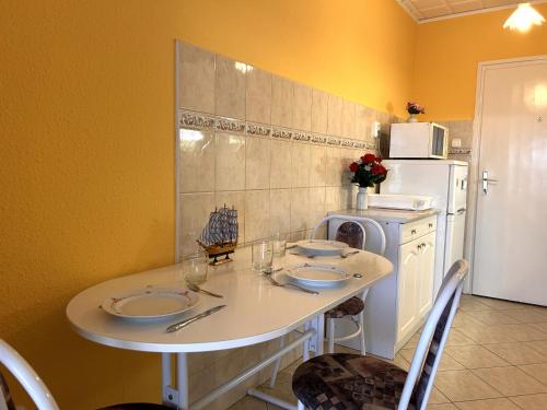 a small kitchen with a table and a refrigerator at Infinity Beach Germering in Balatonfüred