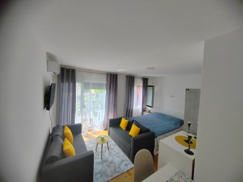 a living room with a blue couch and yellow pillows at OgiApartman in Vrnjačka Banja