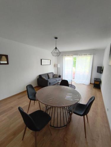 un salon avec une table, des chaises et un canapé dans l'établissement Appartement à 5 min du port, à Vannes