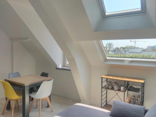 une salle à manger avec une table et des chaises et une fenêtre dans l'établissement T2 centreville, appart lumineux,1 chambre, 4 pers, climatisation, wifi, parking gratuit, à Lorient