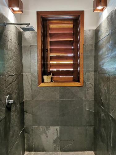 a bathroom with a shower with a window at Villa Guaiuba linda casa com piscina e vista por mar ! in Icaraí