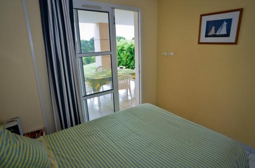 une chambre avec un lit et une porte coulissante en verre dans l'établissement Cap Esterel Garden Flat, à Agay