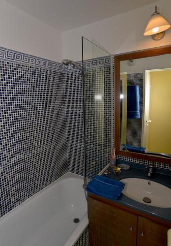 une salle de bain avec une baignoire, un lavabo et un miroir dans l'établissement Cap Esterel Garden Flat, à Agay