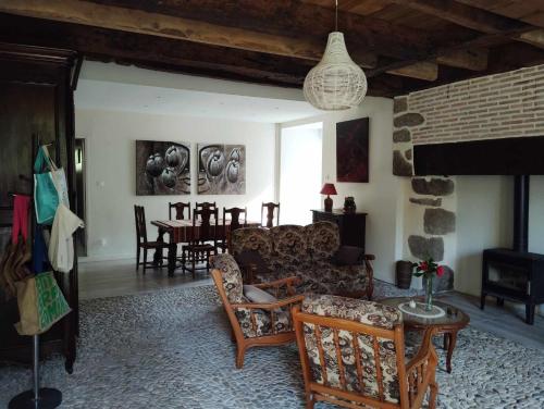 a living room with a couch and chairs and a table at Gîte et chambre d'hôtes Les Authentiques in Saint-Estèphe