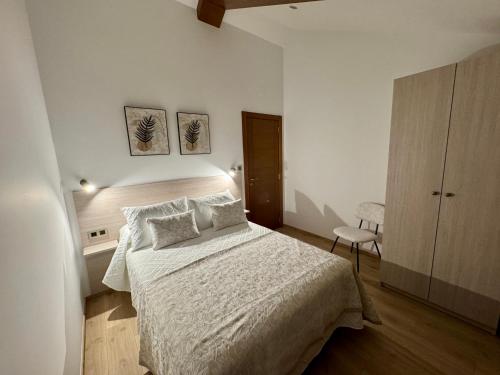 a bedroom with a bed with white sheets and pillows at Mar do Val in Muxia