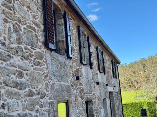 an old stone building with a bunch of windows at Mar do Val in Muxia