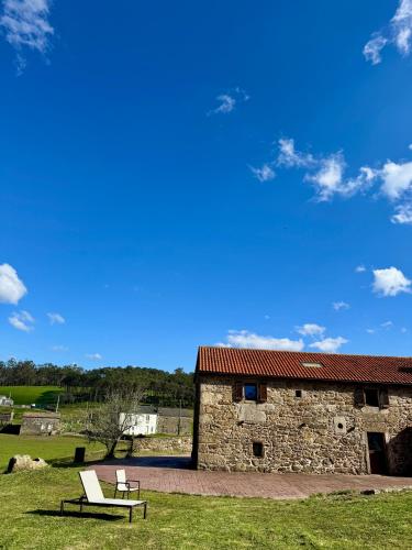 a stone building with a bench in front of it at Mar do Val in Muxia