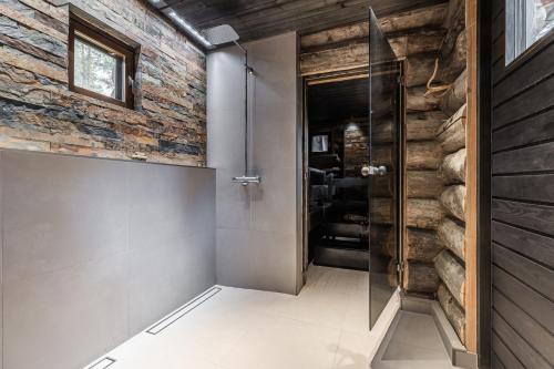 a hallway with a glass door and a brick wall at Villa Riekko by Hillas Villas in Äkäslompolo
