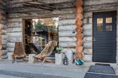 two chairs sitting on the porch of a log cabin at Villa Riekko by Hillas Villas in Äkäslompolo
